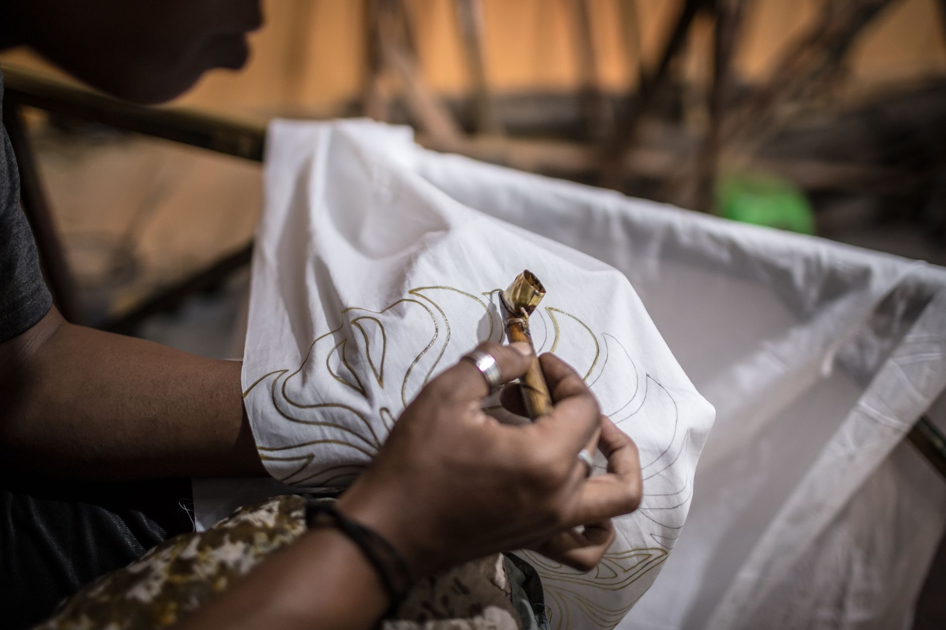 Close-up of an artisan handcrafting a traditional batik design on fabric, highlighting cultural craftsmanship. — Decorating A